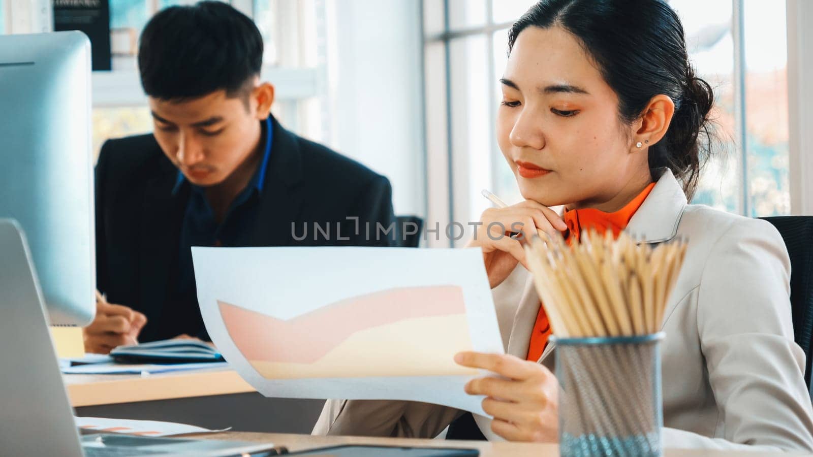 Business people working at table in modern office room while analyzing financial data report . Jivy