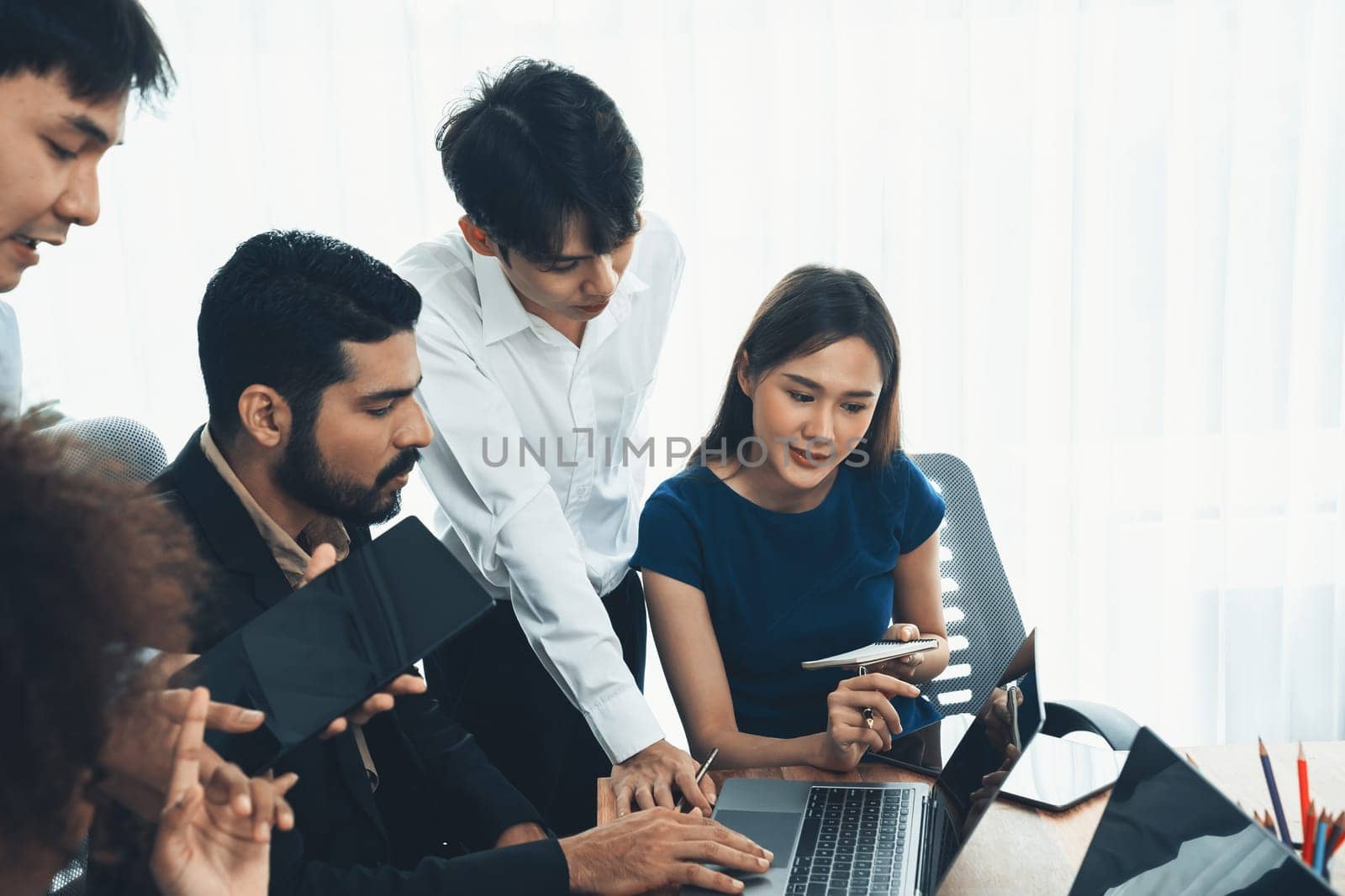 Happy diverse business people work together, discussing in corporate office. Professional and diversity teamwork discuss business plan on desk with laptop. Modern multicultural office worker. Concord