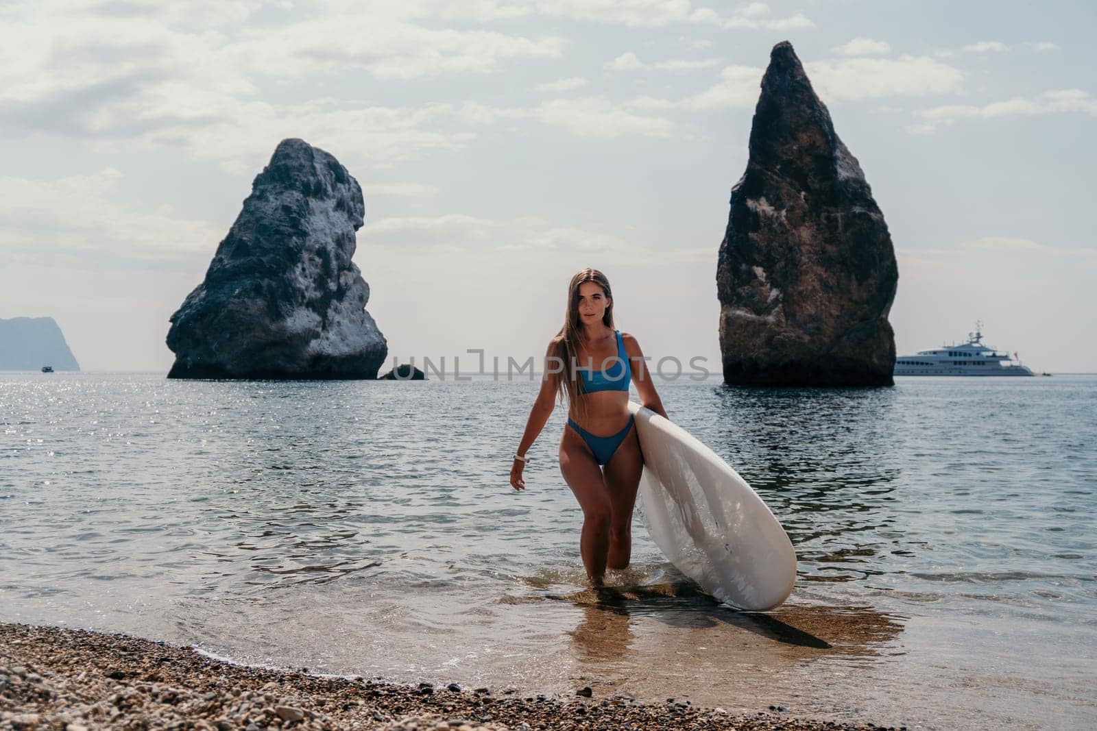 Woman sea sup. Close up portrait of happy young caucasian woman with long hair looking at camera and smiling. Cute woman portrait in bikini posing on sup board in the sea by panophotograph