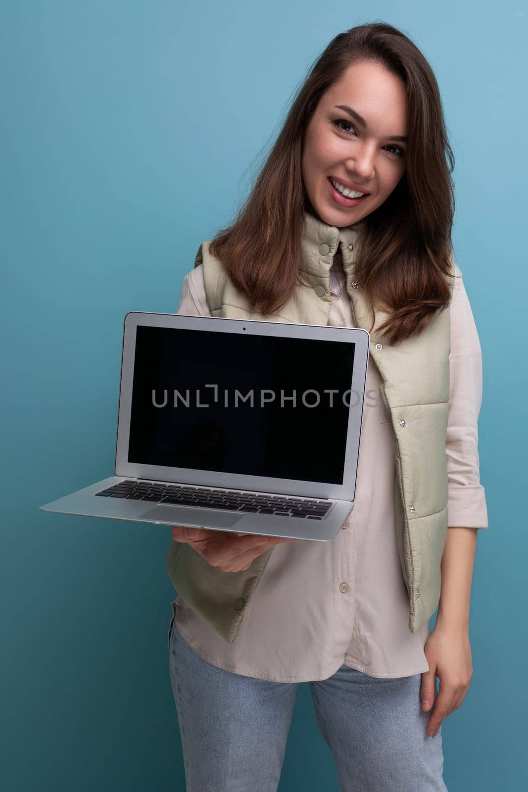 young brunette woman demonstrating commercial offer on laptop screen.