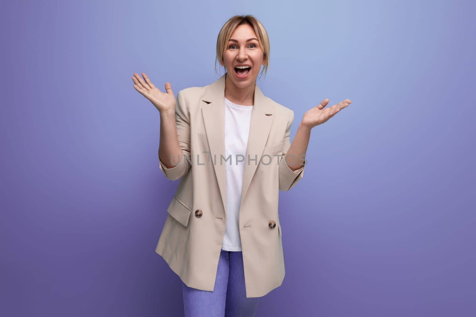 joyful blond business woman in office jacket on studio background.