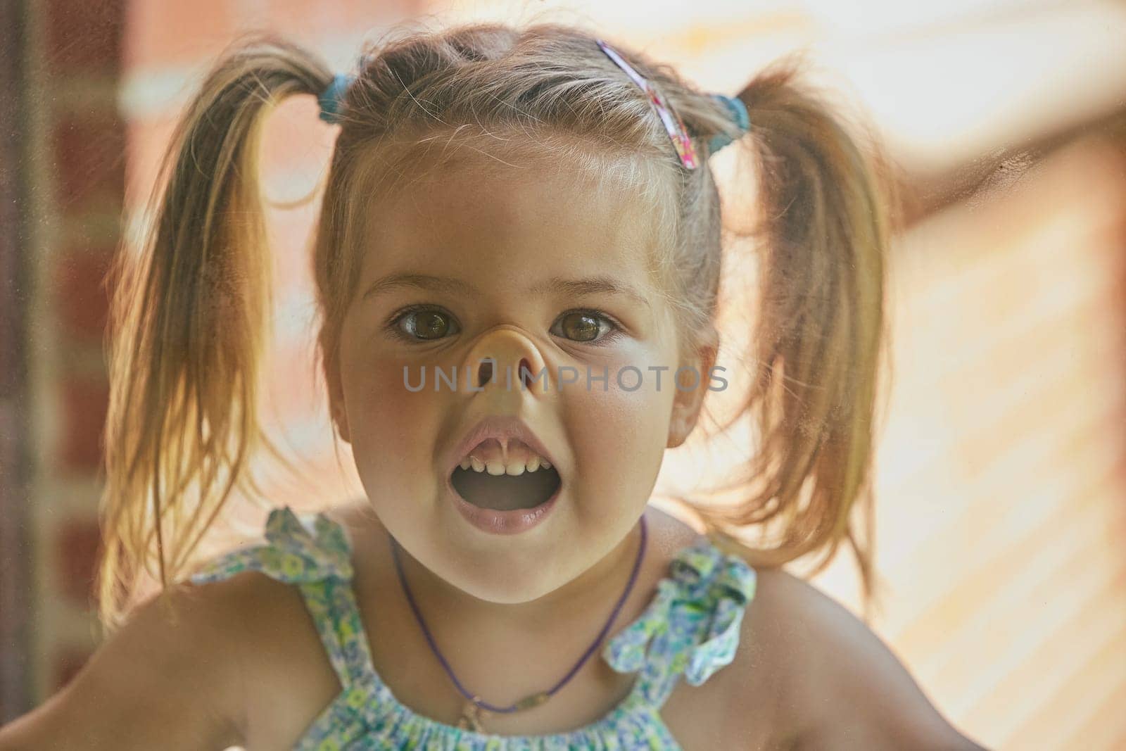 charming child fooling around with his face pressed against the glass by Viktor_Osypenko