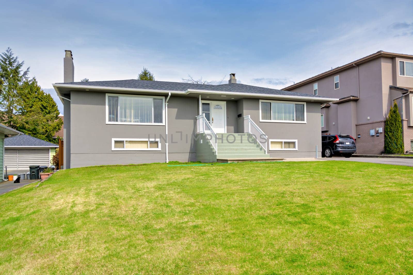 Average residential house with landscaped front yard. Modest tamily house in Canada