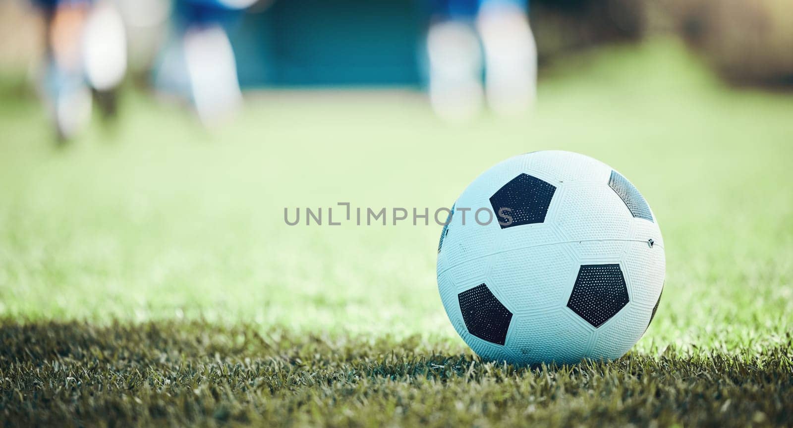 Field, sports and a football on the grass for a game, goal or training in summer. Fitness, playing and gear for soccer, competition or athlete exercise on the ground for a match or cardio in nature by YuriArcurs