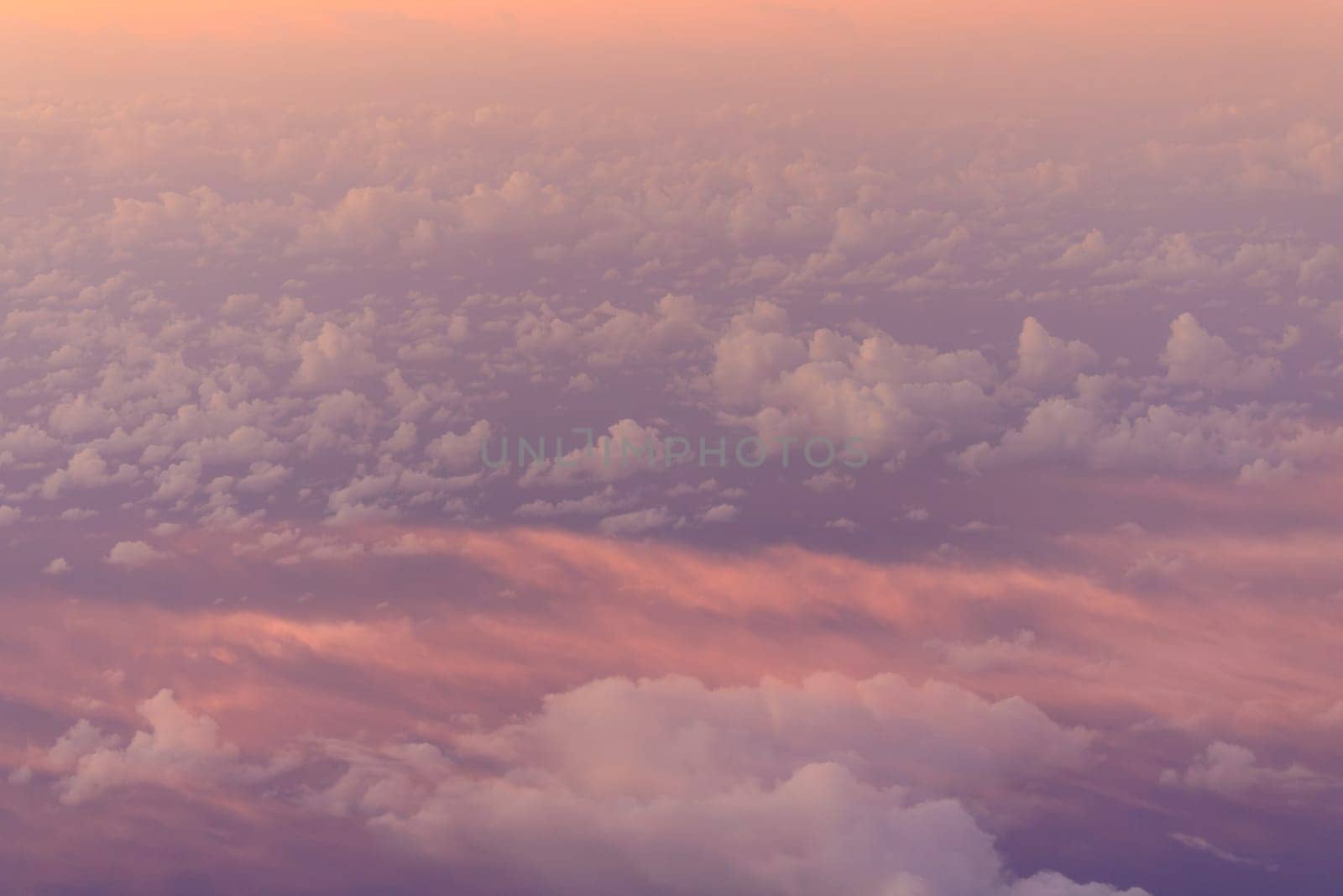 Hazy pink glow and clouds at sunrise in upper atmosphere by Osaze