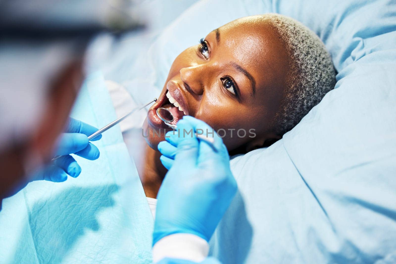 Dentist, inspection and woman with tools in mouth at clinic for cavity, teeth whitening and helping hand for pain. Dental surgeon, African patient and mirror for exam, care or check for healthy smile by YuriArcurs