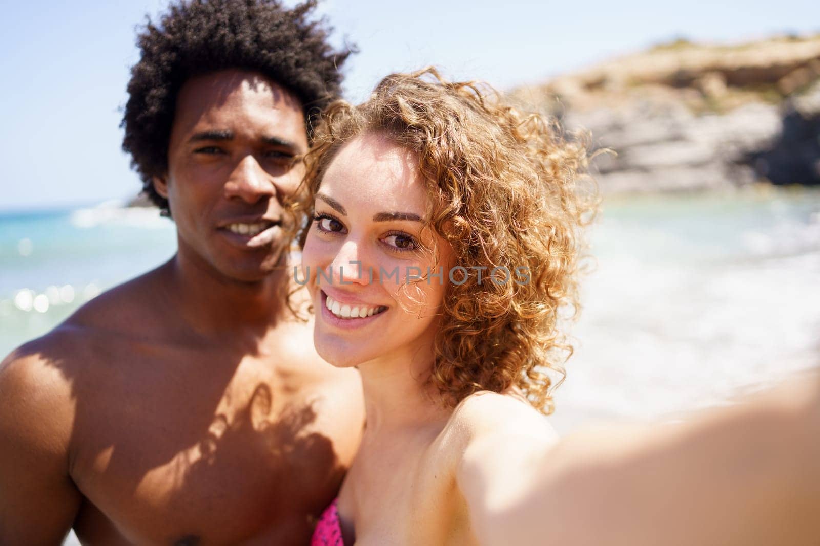 Selfie of happy diverse couple on beach by javiindy