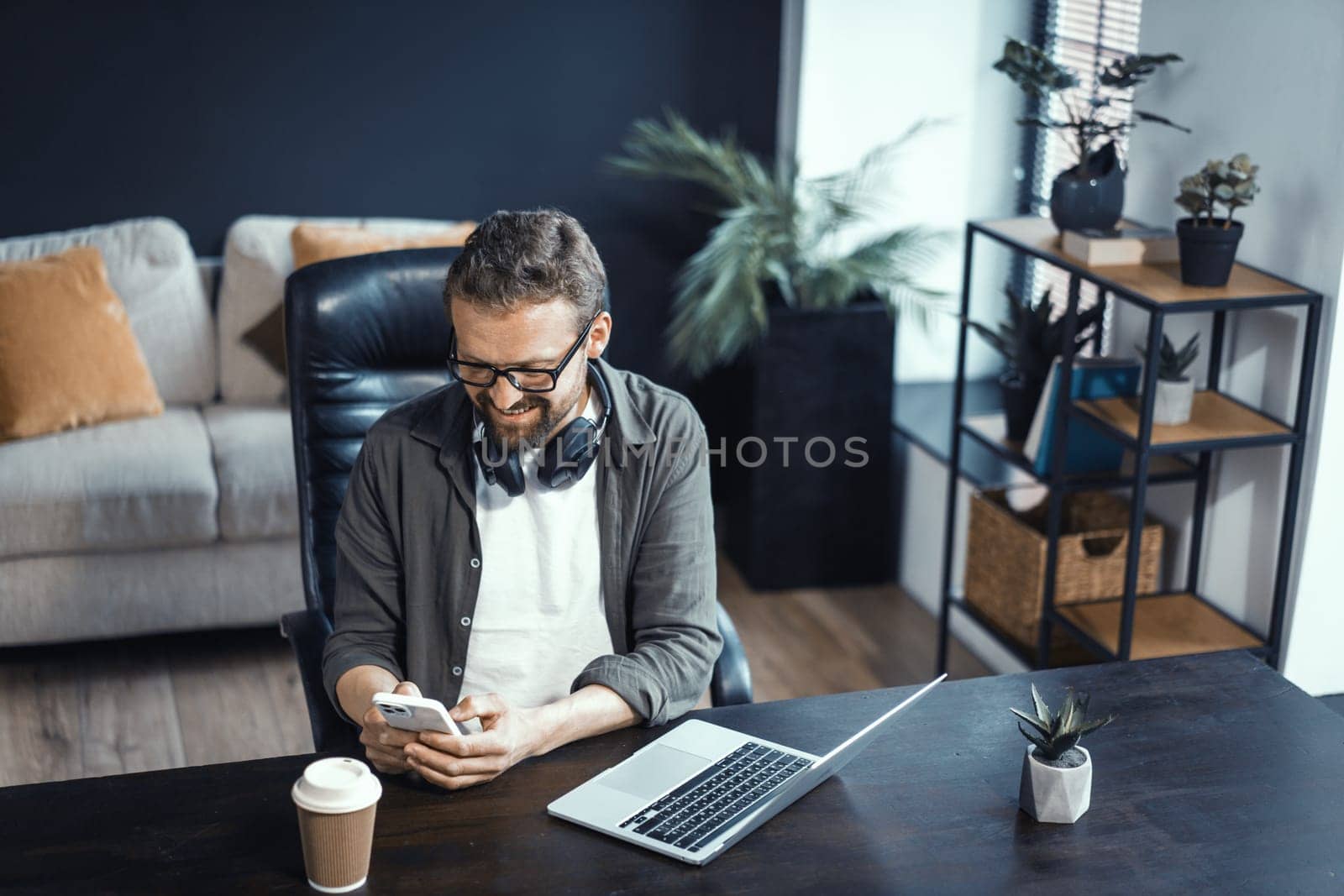 Concept of working from home, featuring mid-aged man working on laptop. Man seen in comfortable home office environment, highlighting convenience and benefits of working from comfort of one's own space by LipikStockMedia