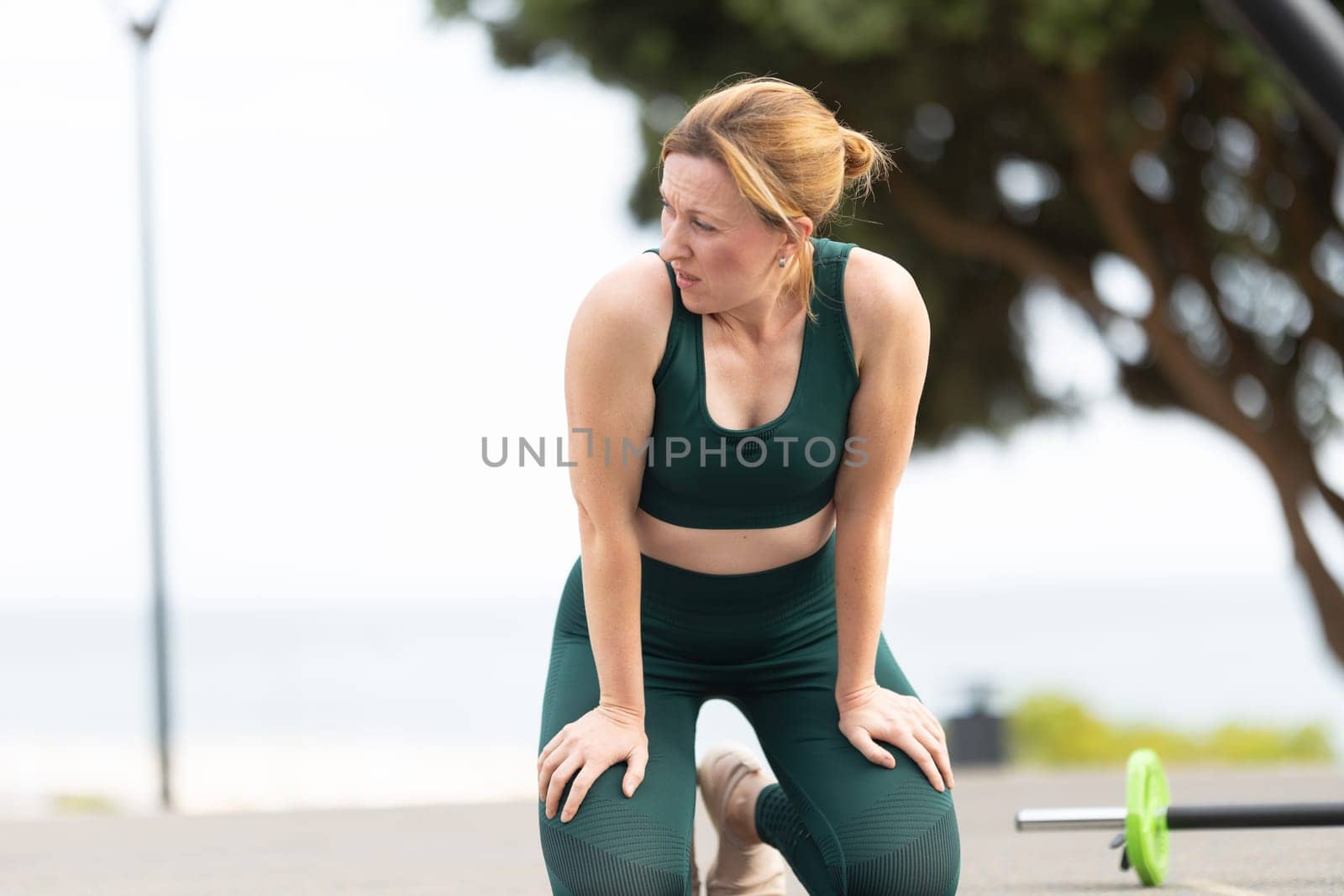 Adult sportive woman with no make up doing fitness outdoors. Mid shot