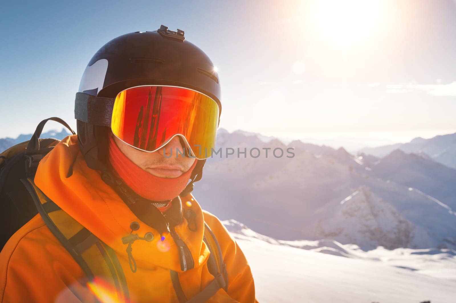 young man in ski goggles and a helmet on a sunny snowy ski slope. Portrait of a confident sportsman by yanik88