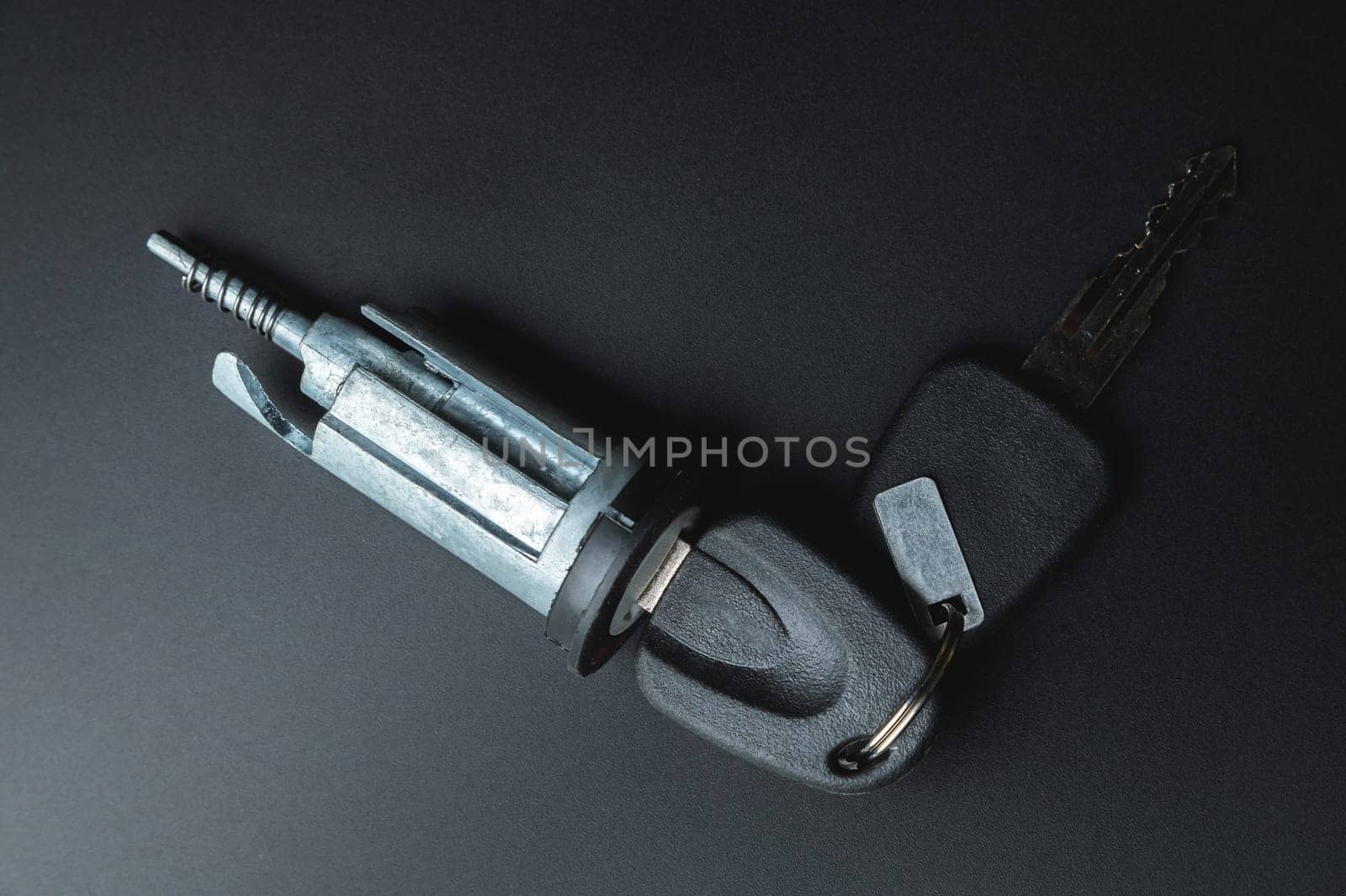 ignition lock with car key. On a black background. Spare ignition key block.