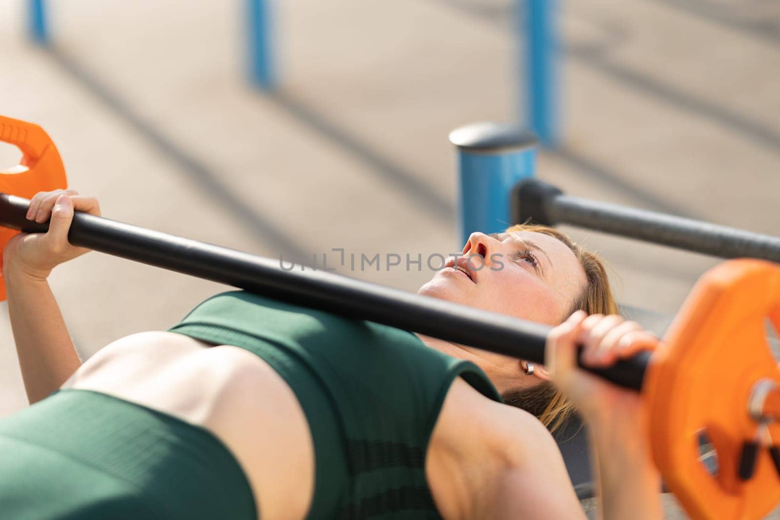 Adult fitness woman training her hands with lifting dumbbell. Mid shot