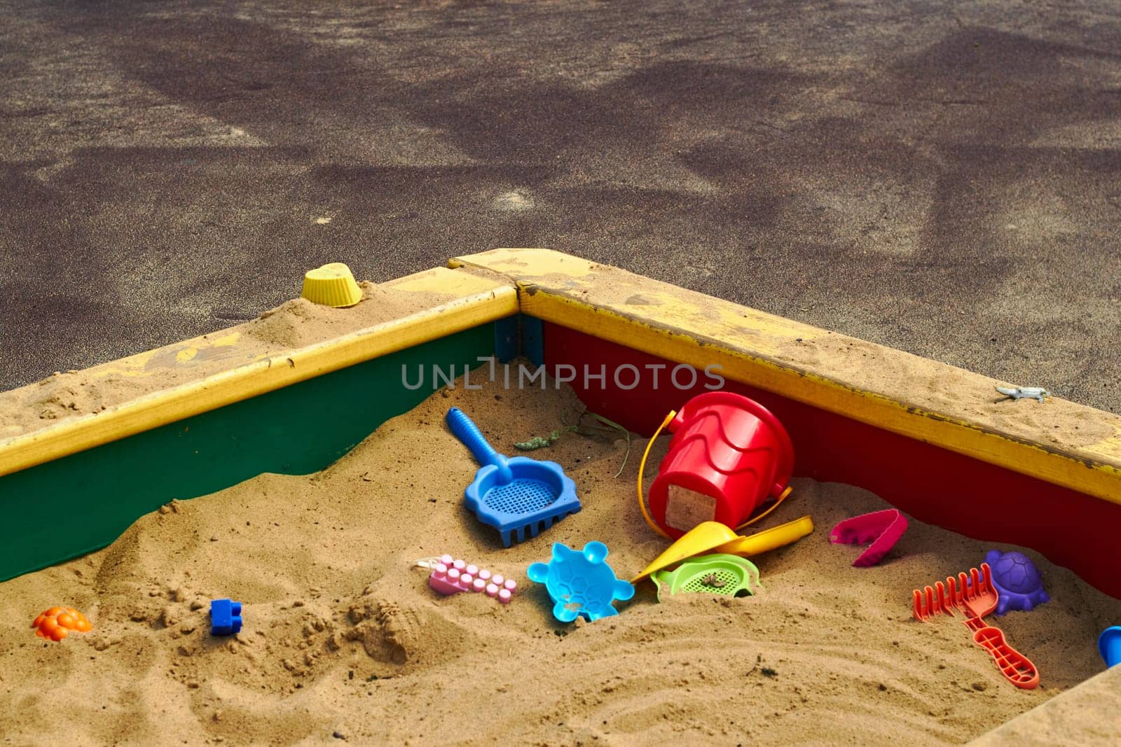 Photo of plastic children toys in sandbox at playground. Children's outdoor games. Entertainment and games for kids.