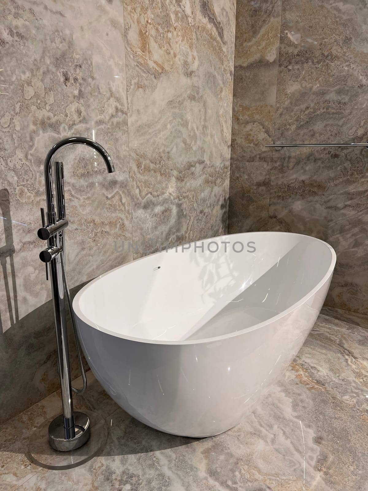 Modern ceramic bathtub . White tub in minimalistic bathroom interior. Porcelain bathtub with classic design in comfortable apartment or hotel room. home decor in spa center