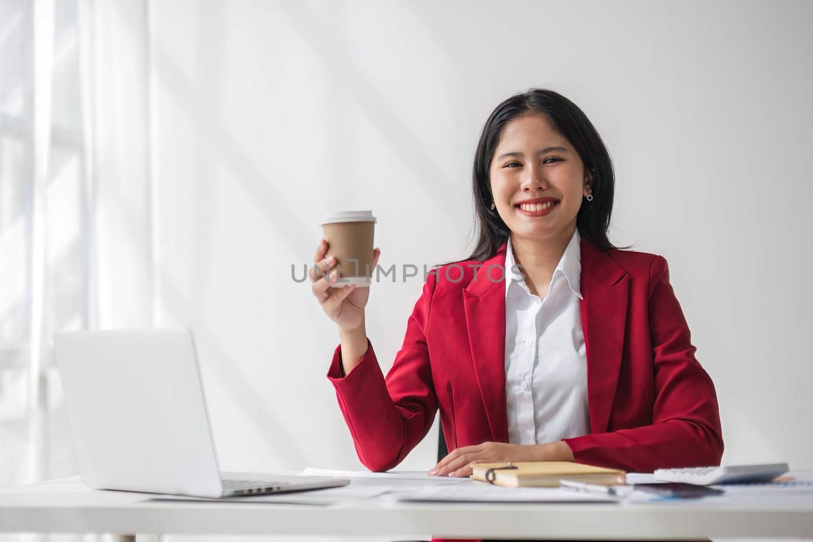 Cheerful business lady working on laptop in office, Asian happy beautiful businesswoman in formal suit work in workplace. Attractive female employee office worker smile. by wichayada