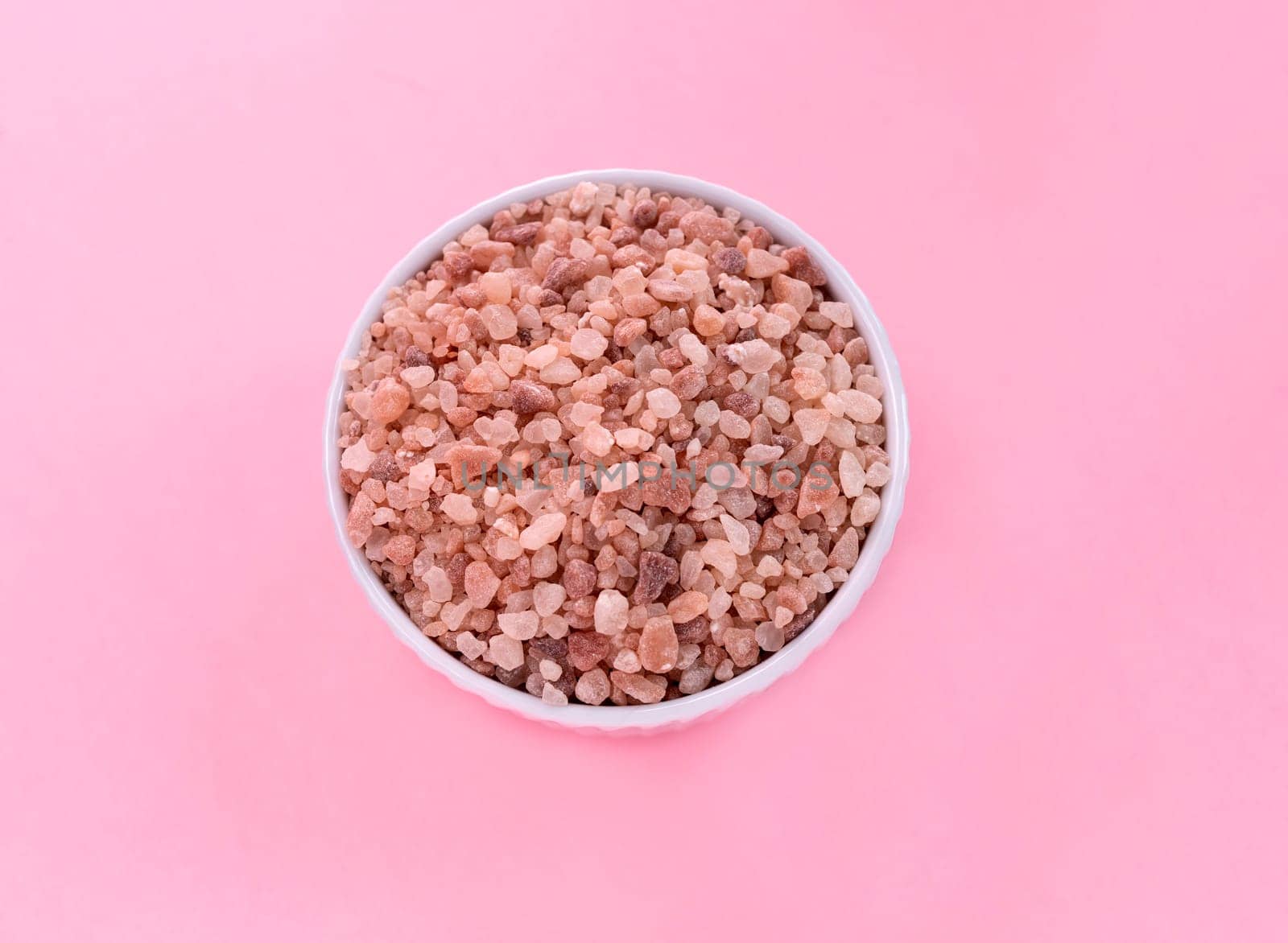 Flatly Pink Himalayan Rock Salt, Halite In White Ceramic Bowl On Pink Background. Top View Horizontal Plane, Copy Space For Text. High quality photo by netatsi