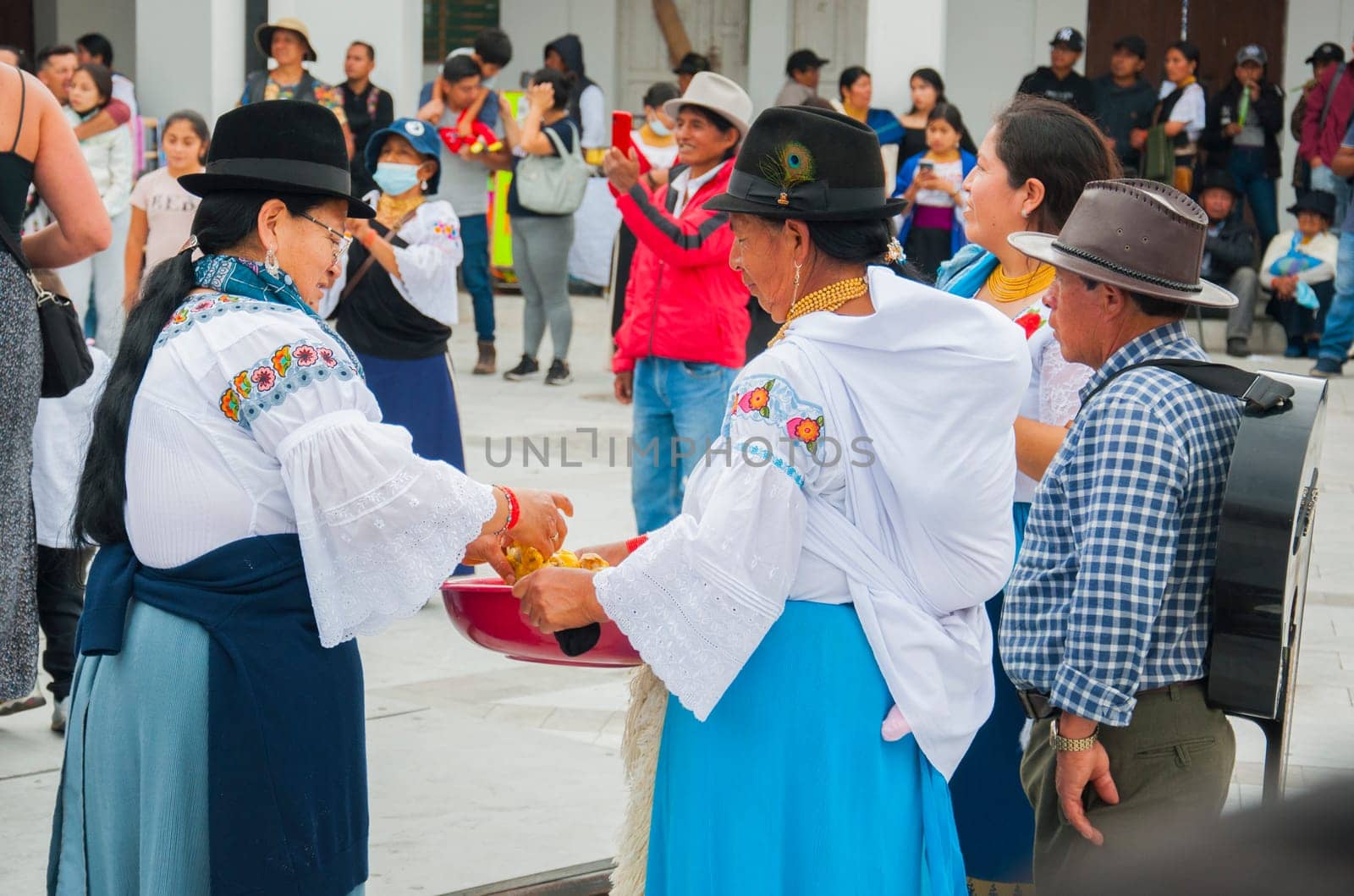 Otavalo, Ecuador - 24 de junio de 2023: two indigenous women in traditional clothing preparing food for people attending inti raymi. High quality photo
