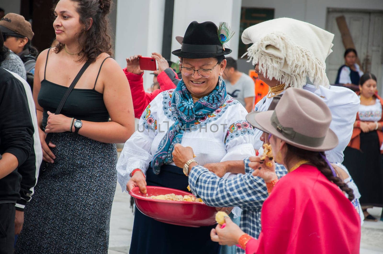 Otavalo, Ecuador - 24 de junio de 2023: indigenous woman from cayambe distributing nickname and chicken to the people who dance in the inti raymi of otavalo. High quality photo