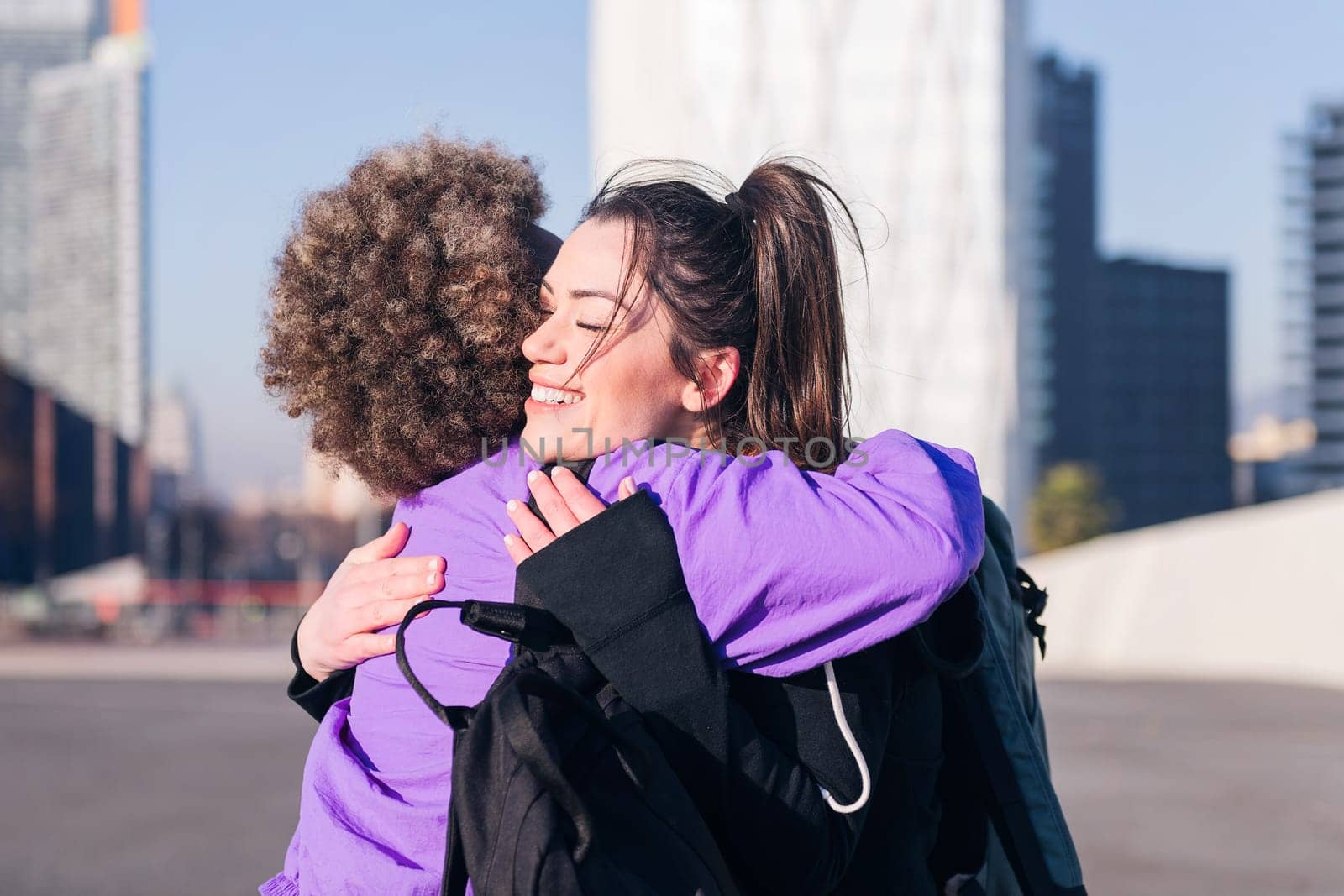 portrait of two happy sportswomen embracing before running in the city, concept of friendship and sportive lifestyle