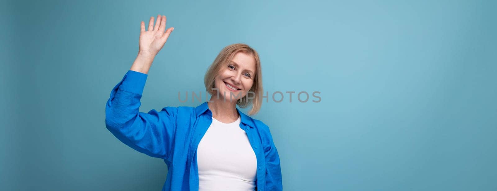 smiling blonde middle-aged woman with bob haircut on studio background.