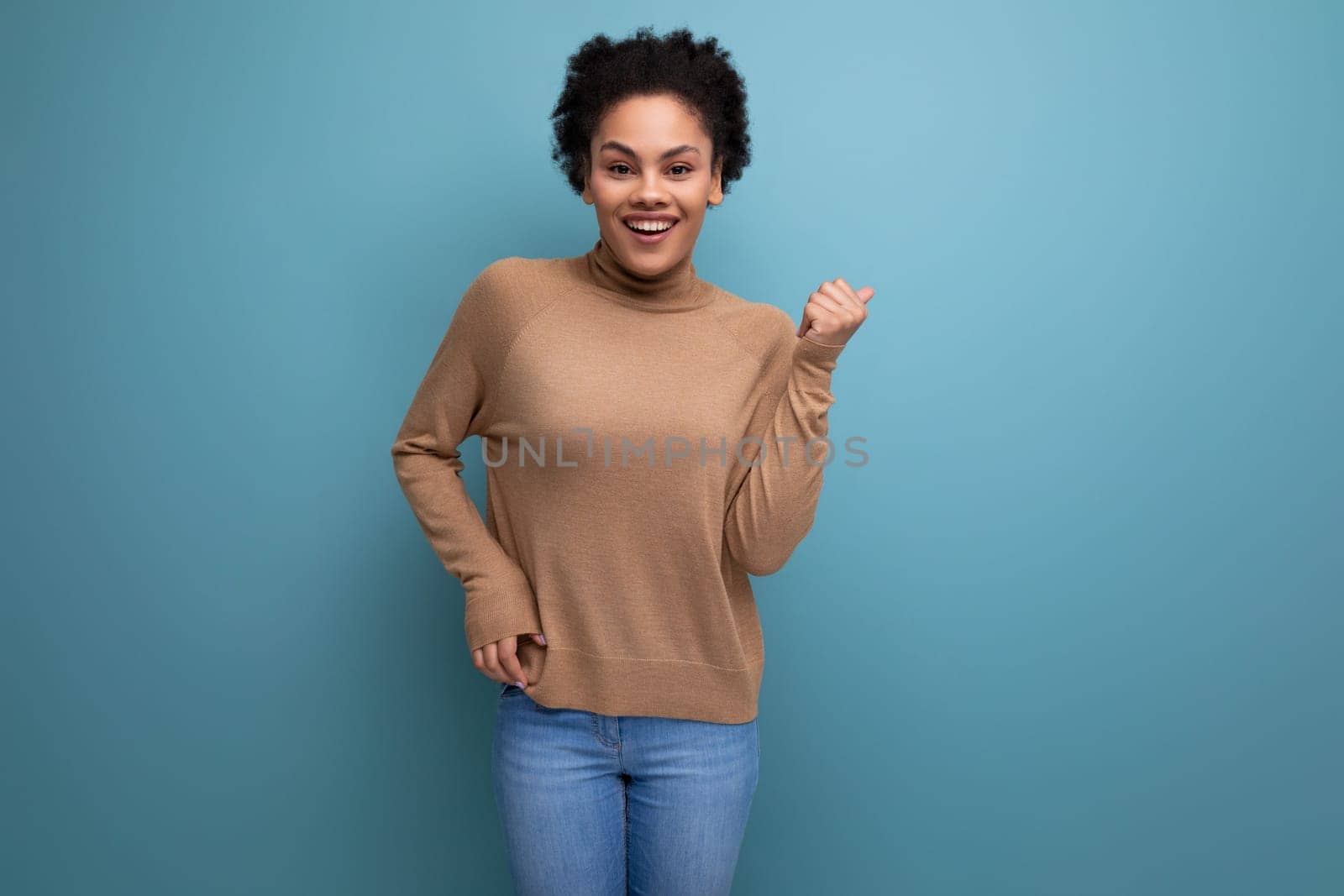 young positive hispanic lady with afro curly hair smiling on background with copy space.