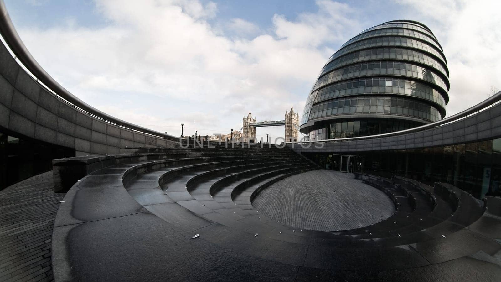 London, United Kingdom - February 10, 2007: Extreme wide (fisheye) photo, City hall and Tower bridge as seen from The Scoop (nearby sunken amphitheatre)