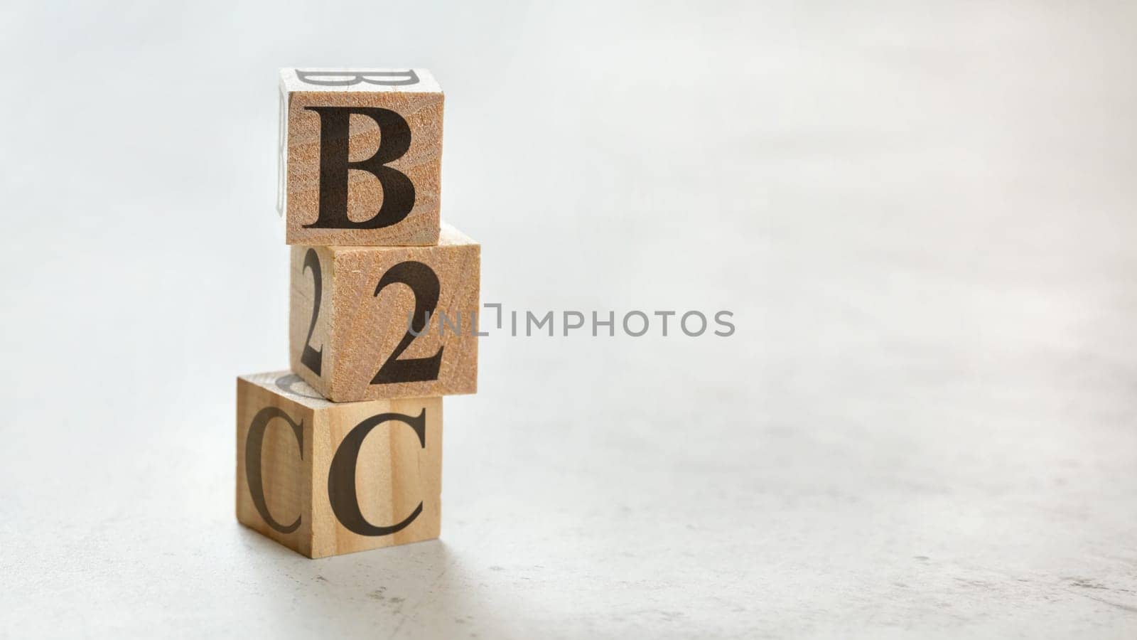 Pile with three wooden cubes - letters B2C meaning Business to customer on them, space for more text / images at right side.