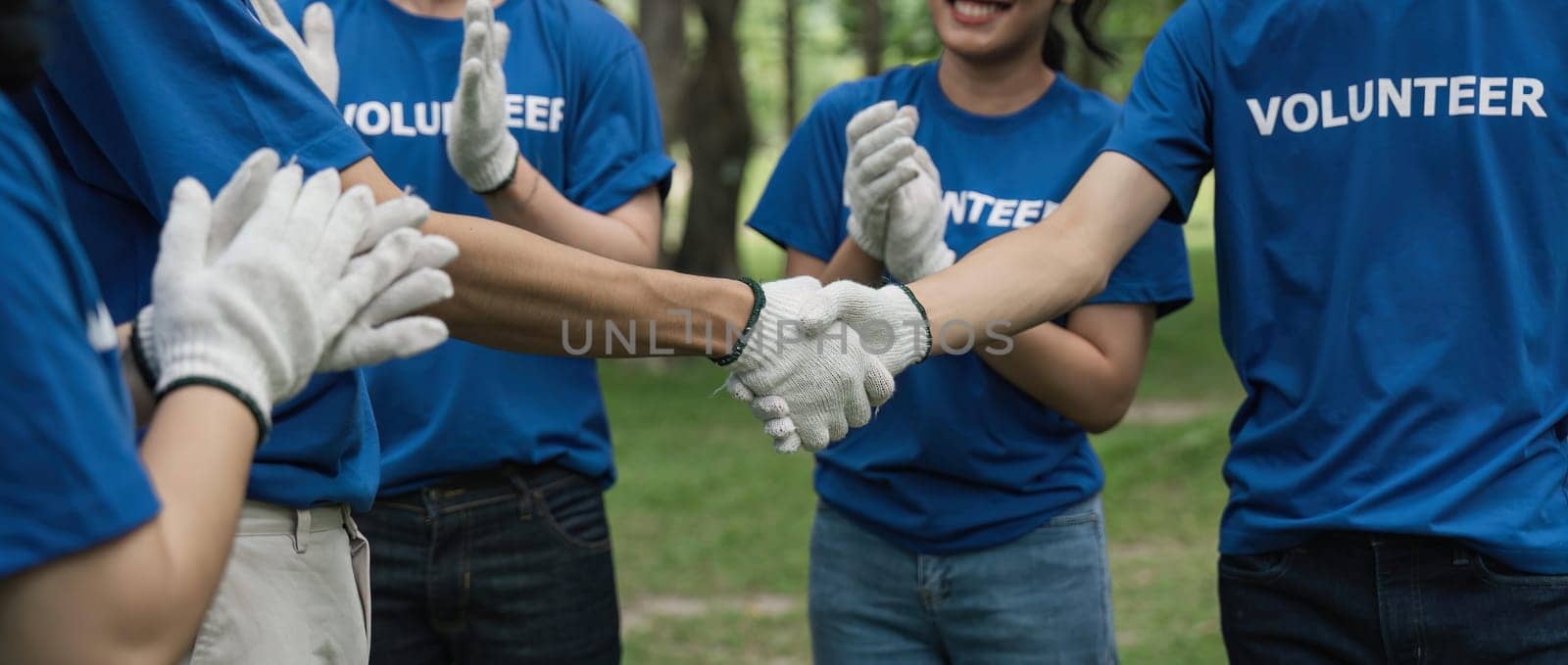 Environmentalist volunteers planting new tree and handshaking by nateemee