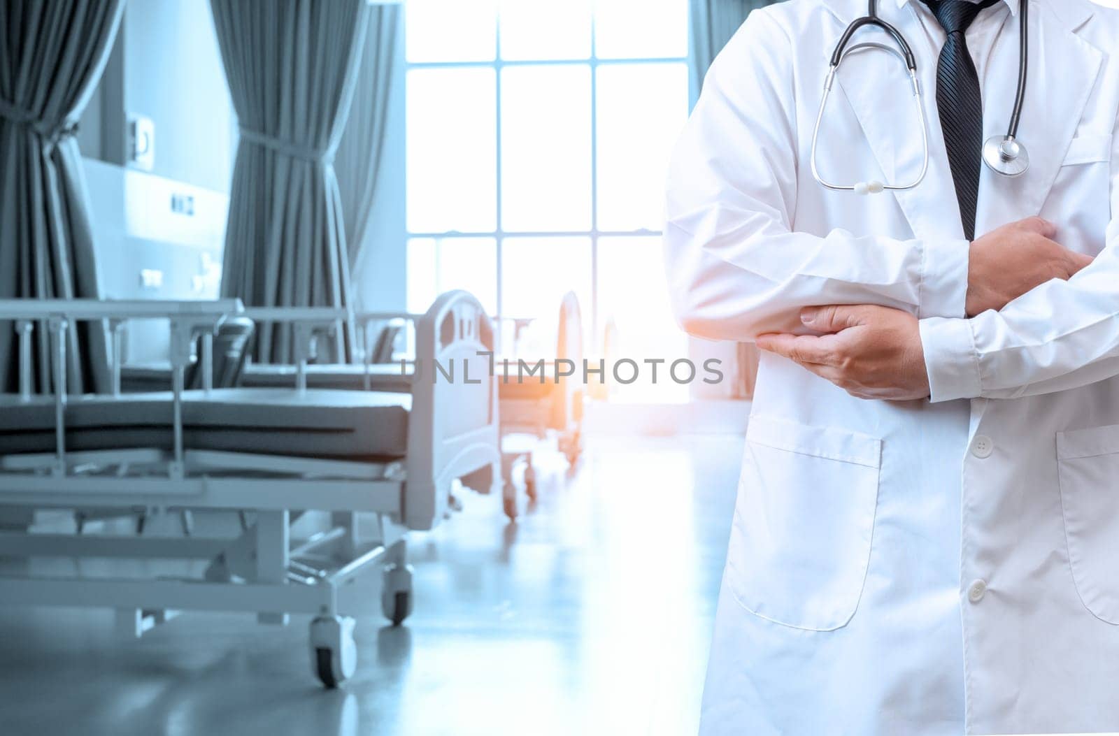 Doctor in lab coat with arms crossed on hospital interior background. Medical concept. Medical information search concept. Disease treatment concept. insurance concept.