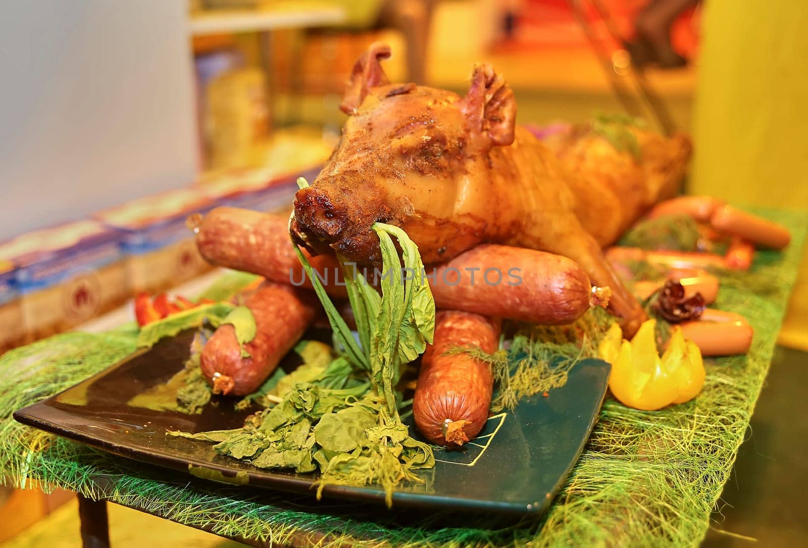 Grilled whole pig ready to serve. Sausage and a young pig on a platter.