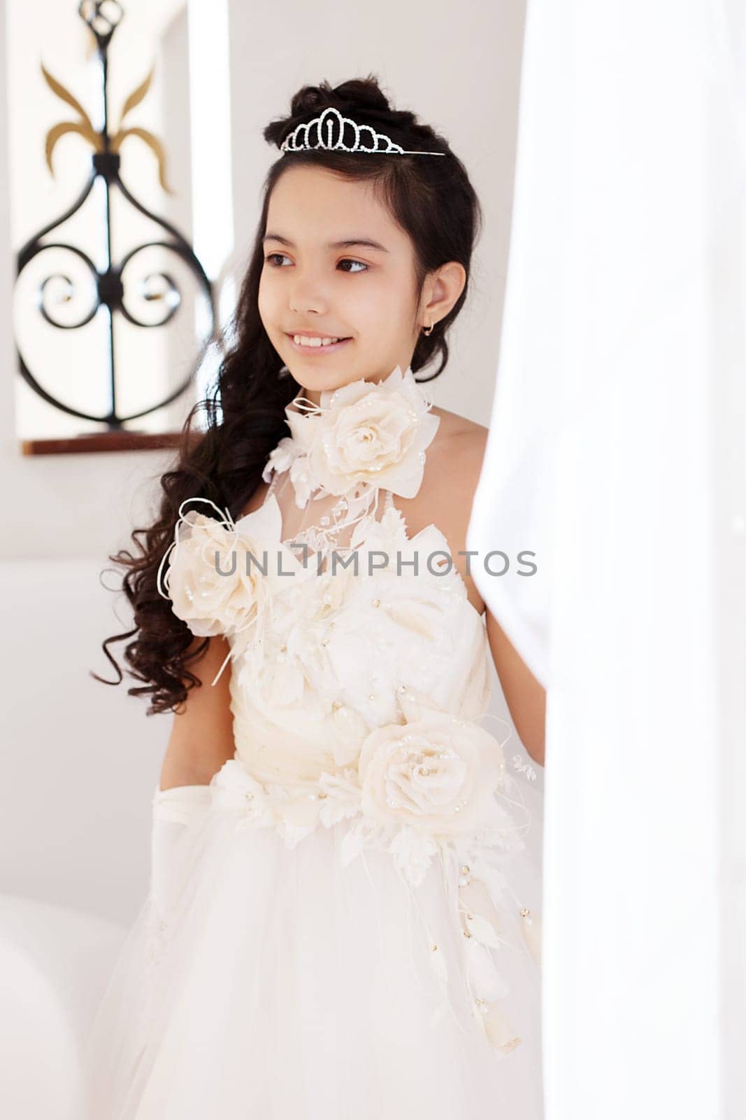 Portrait of pretty little girl posing in chic white dress