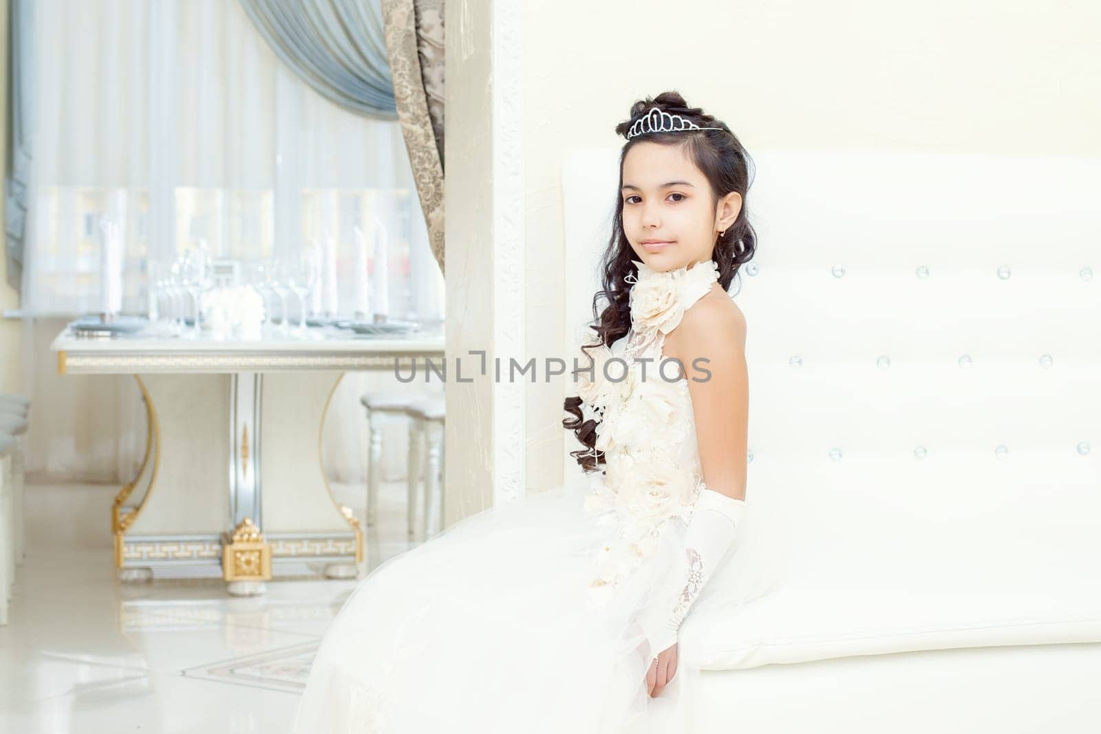 Image of lovely little girl posing in white luxurious dress