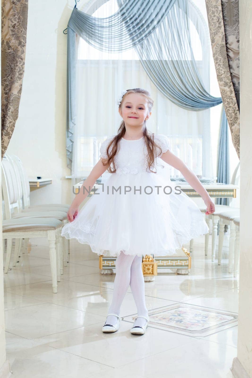 Image of amusing little girl posing in hotel restaurant