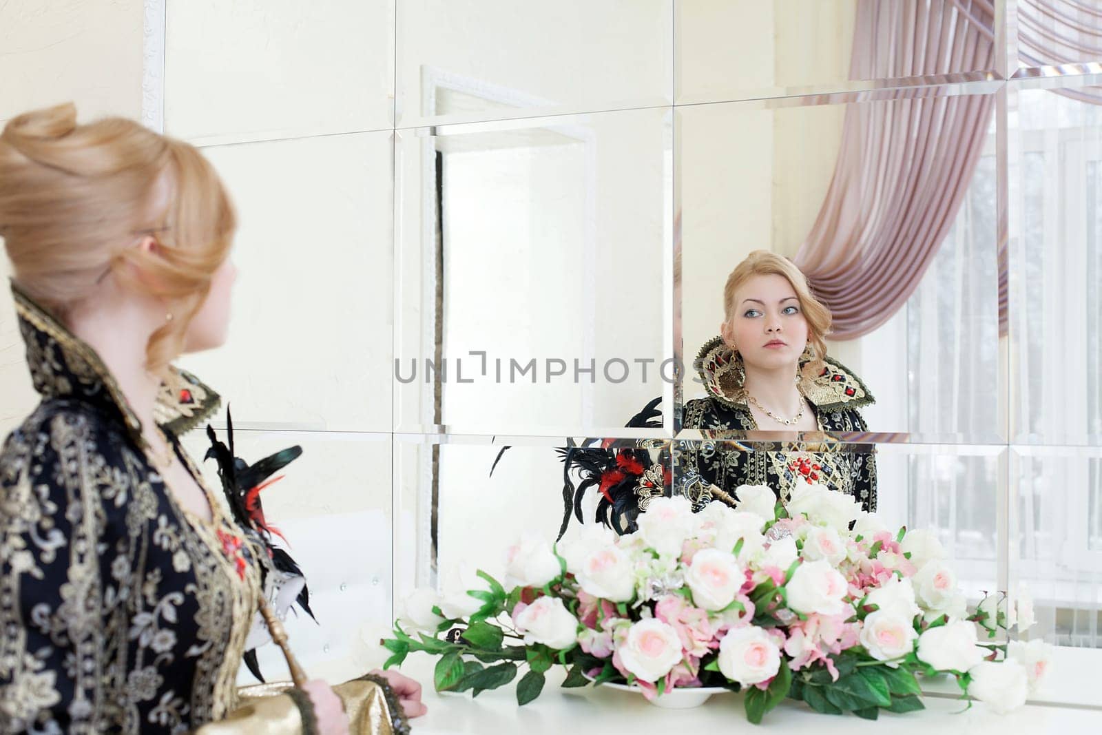 Portrait of young actress posing looking at her reflection in mirror