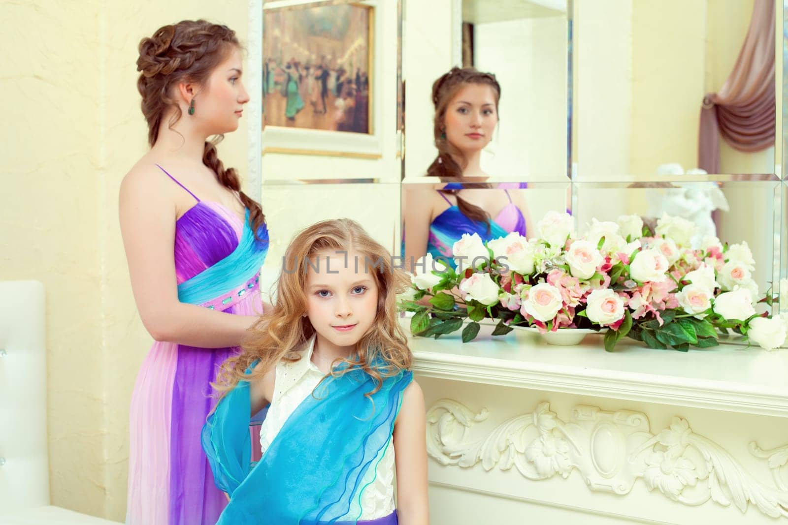 Cute elegant sisters posing before mirror, close-up