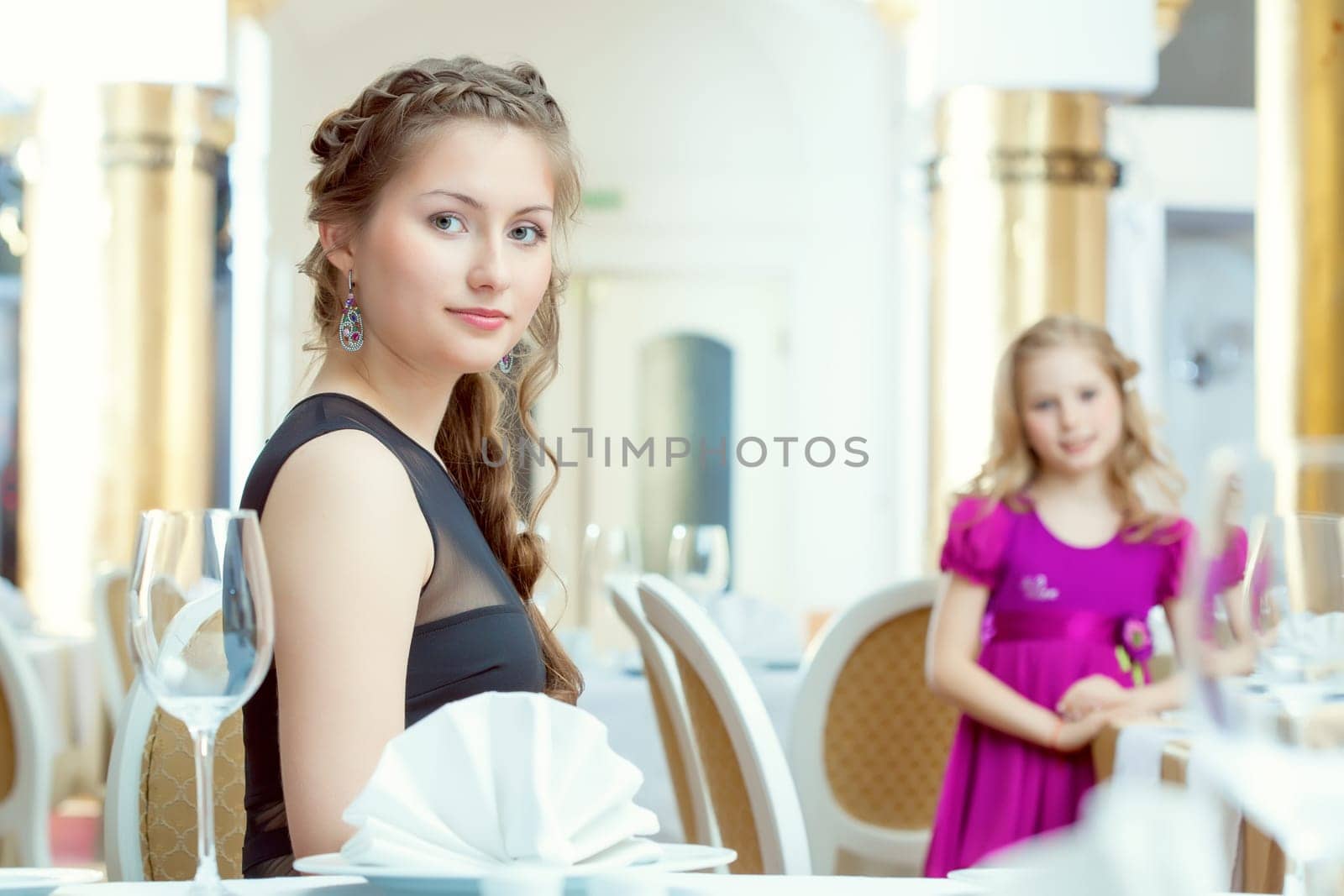 Image of pretty young sisters posing at restaurant