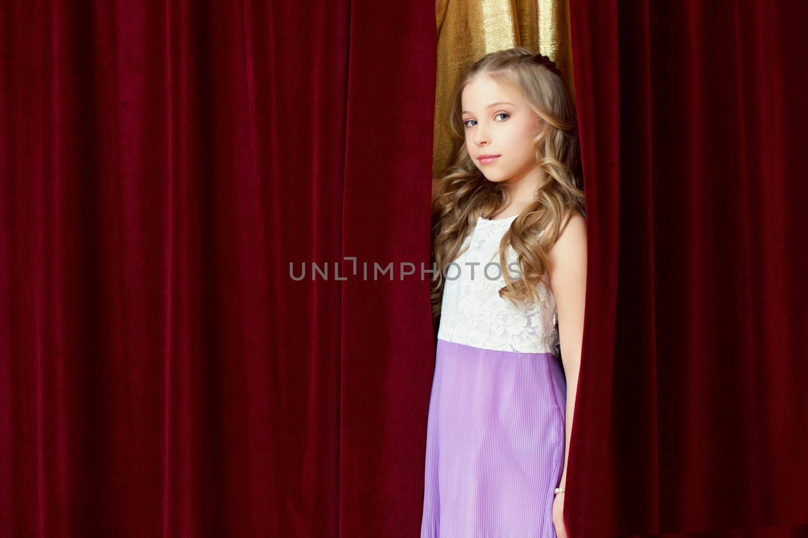 Pretty blonde girl posing looking out curtain, close-up