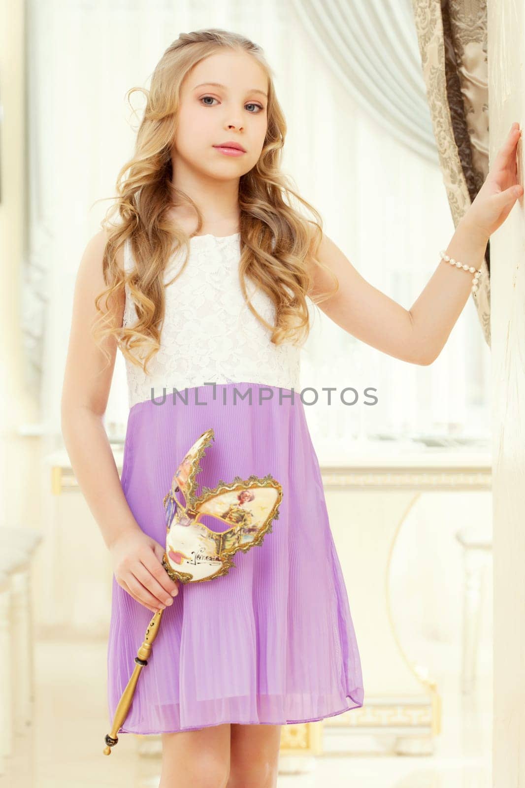 Portrait of blond elegant girl posing with mask in hands