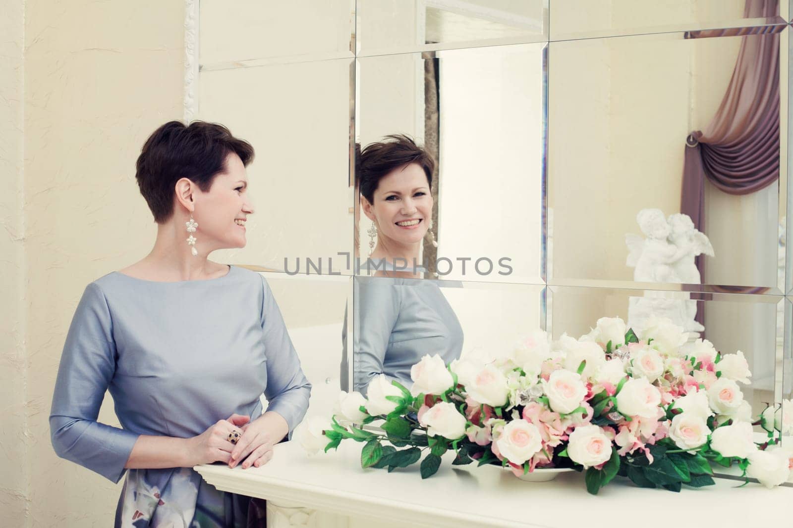 Cheerful middle aged woman laughing in mirror, close-up