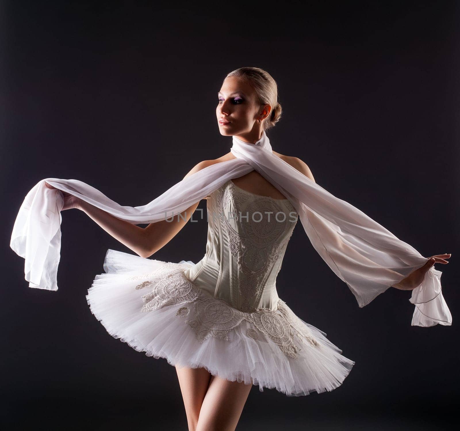Portrait of cute young woman posing like ballerina in studio