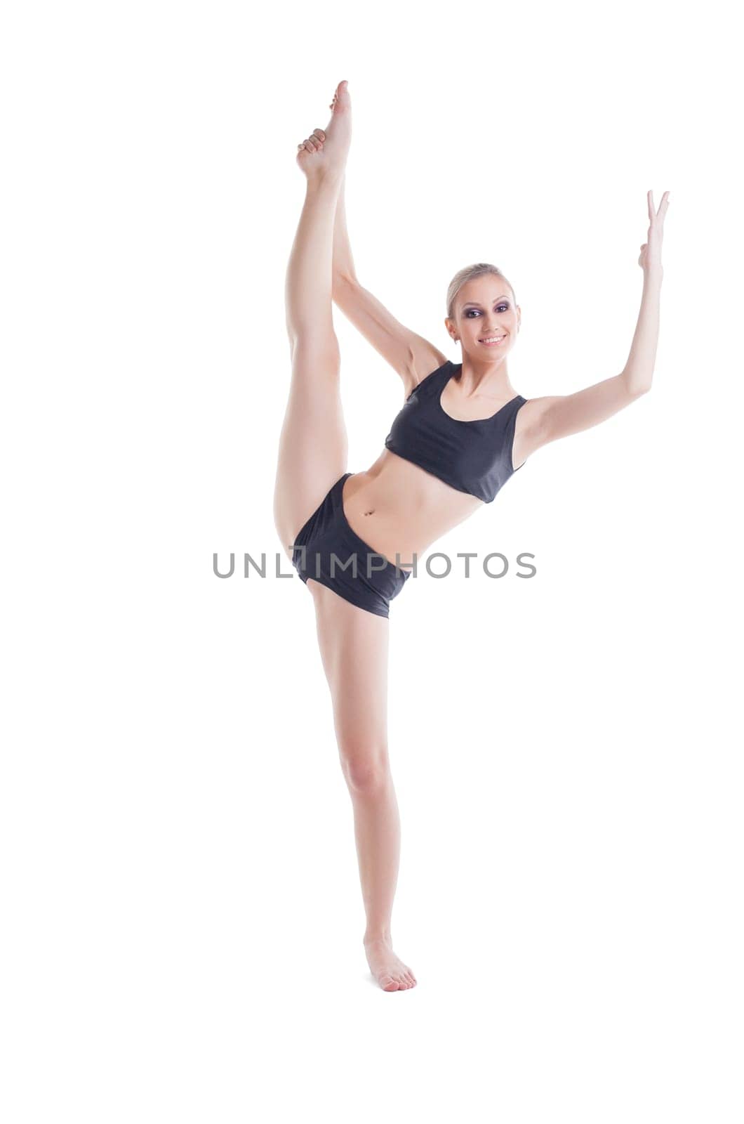 Cheerful young blonde doing stretching exercises, isolated on white