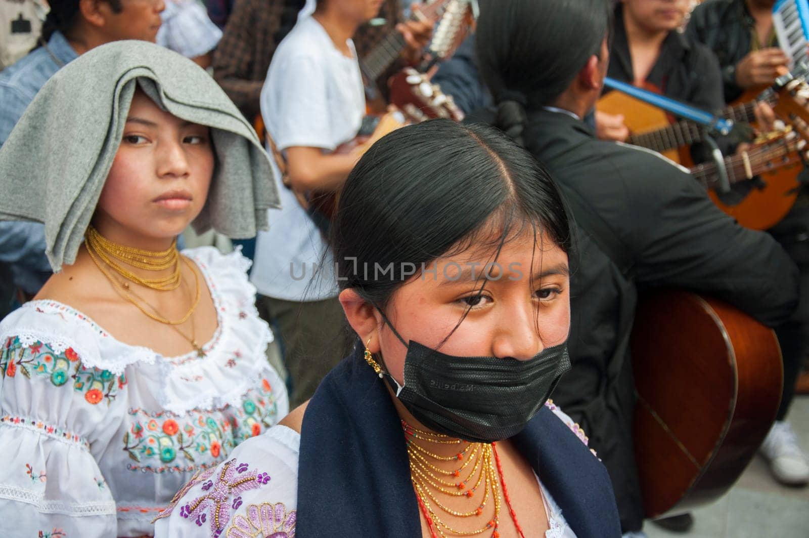 Otavalo, Ecuador - 24 de junio de 2023: young indigenous people in the inti raymi, one with a mask and the other without a mask. High quality photo