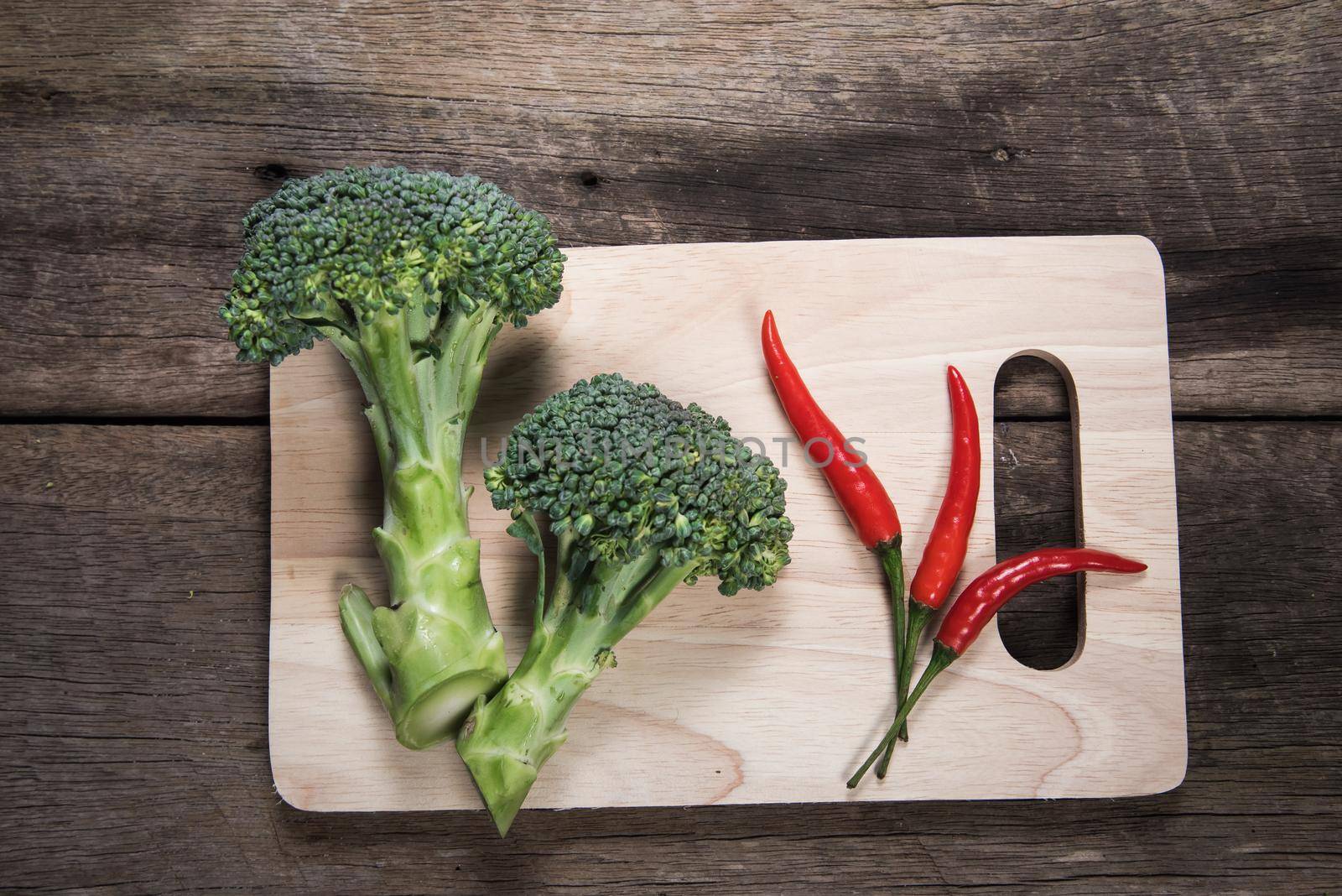 Fresh broccoli and chilli on wood table background. top view by Wmpix