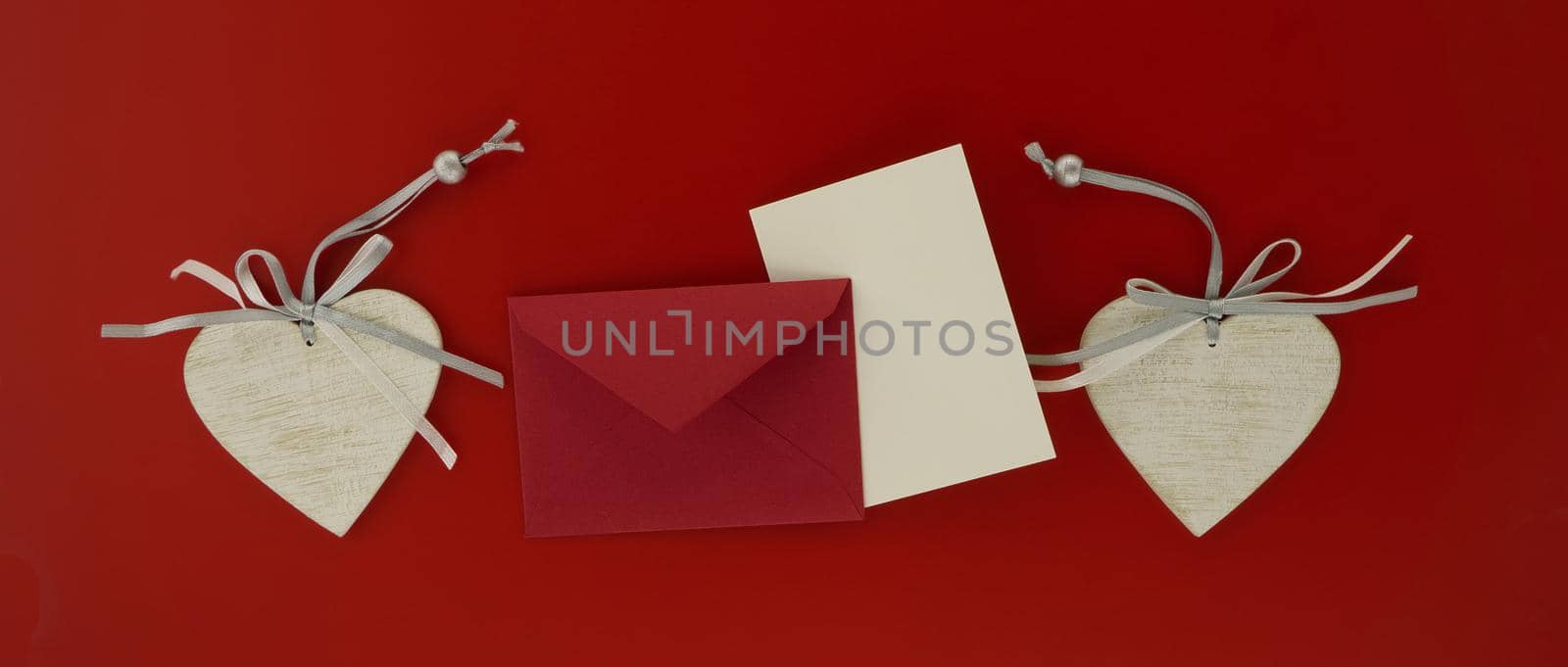 Valentines letter banner with decorative hearts and envelope over a matching red background in a concept of romance and love