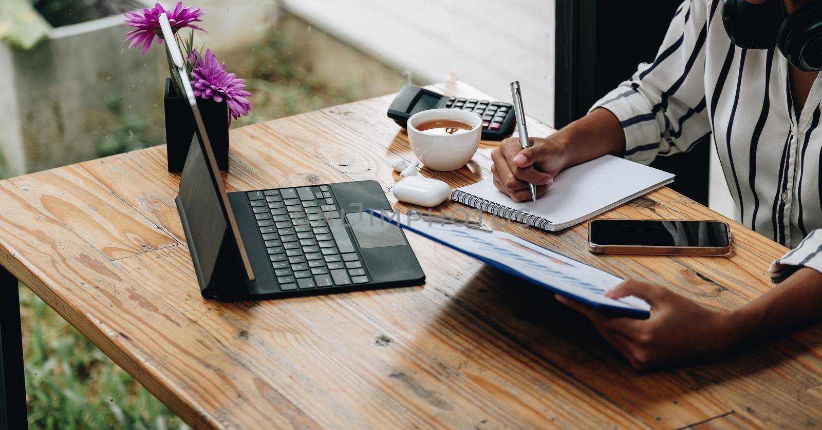 shot of female accounting bookkeeper providing accounting service for small businesses, holding pen to make notes and using calculator, woman using digital tablet and calculator.