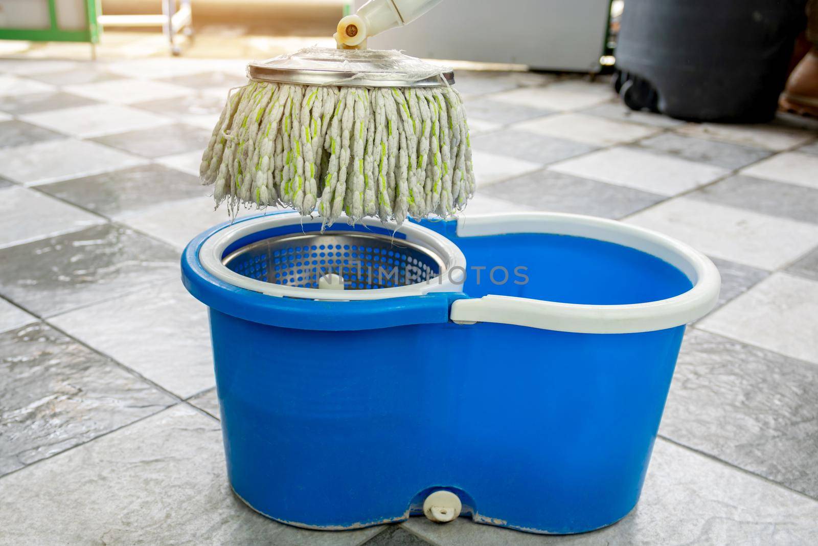 Close-up of mops and a bucket of products for cleaning floors.