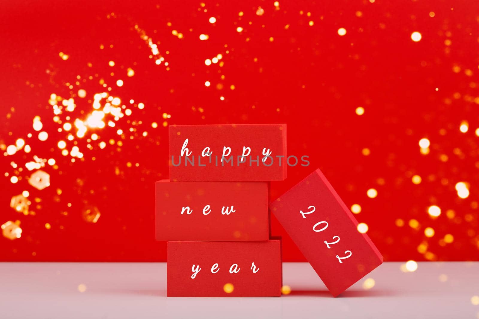 Happy New Year red minimal trendy concept. Modern festive composition with red toy blocks with written Happy New Year 2022 text against red background