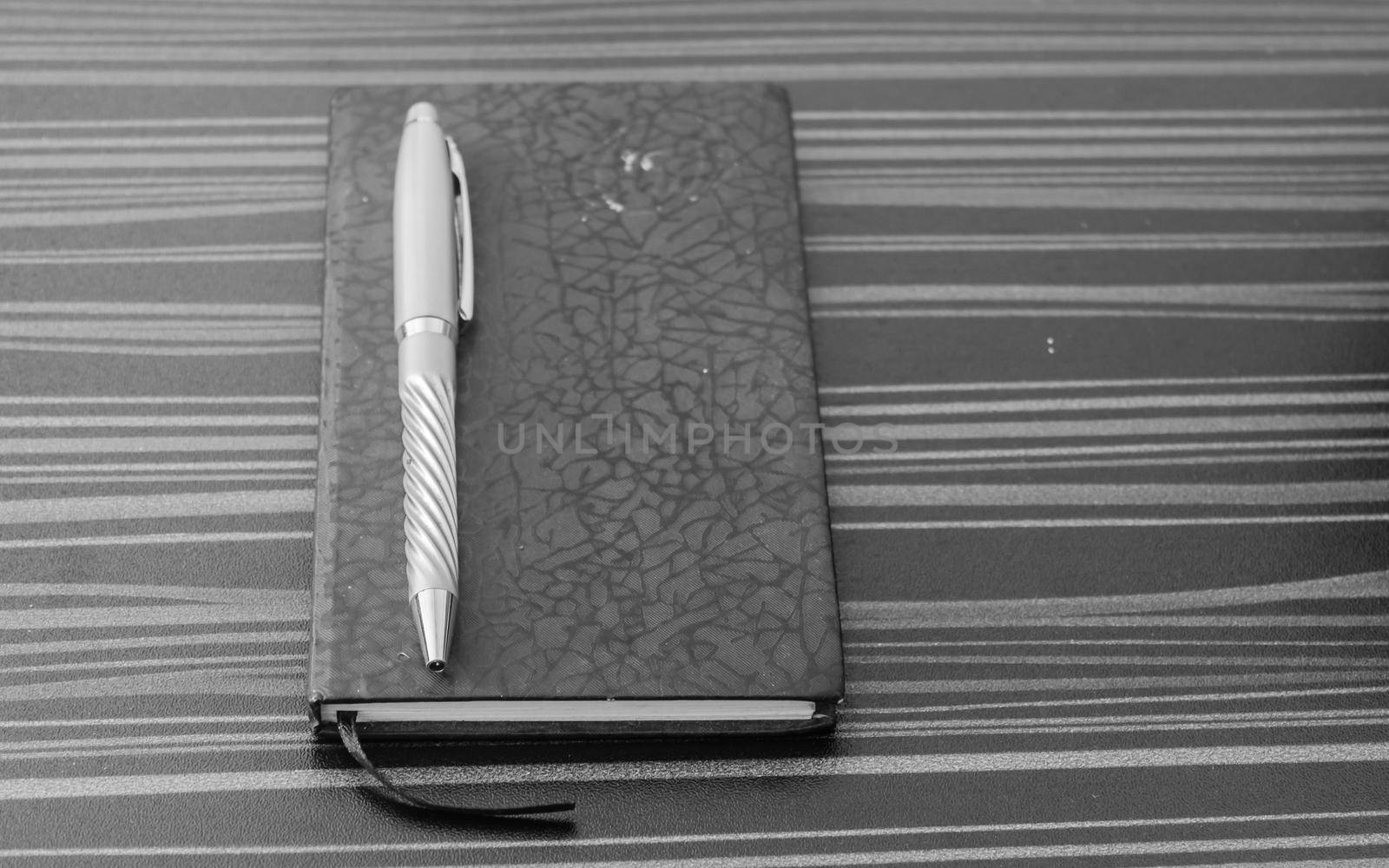 Pen and notebook on office table. Table top view. Corporate business background.