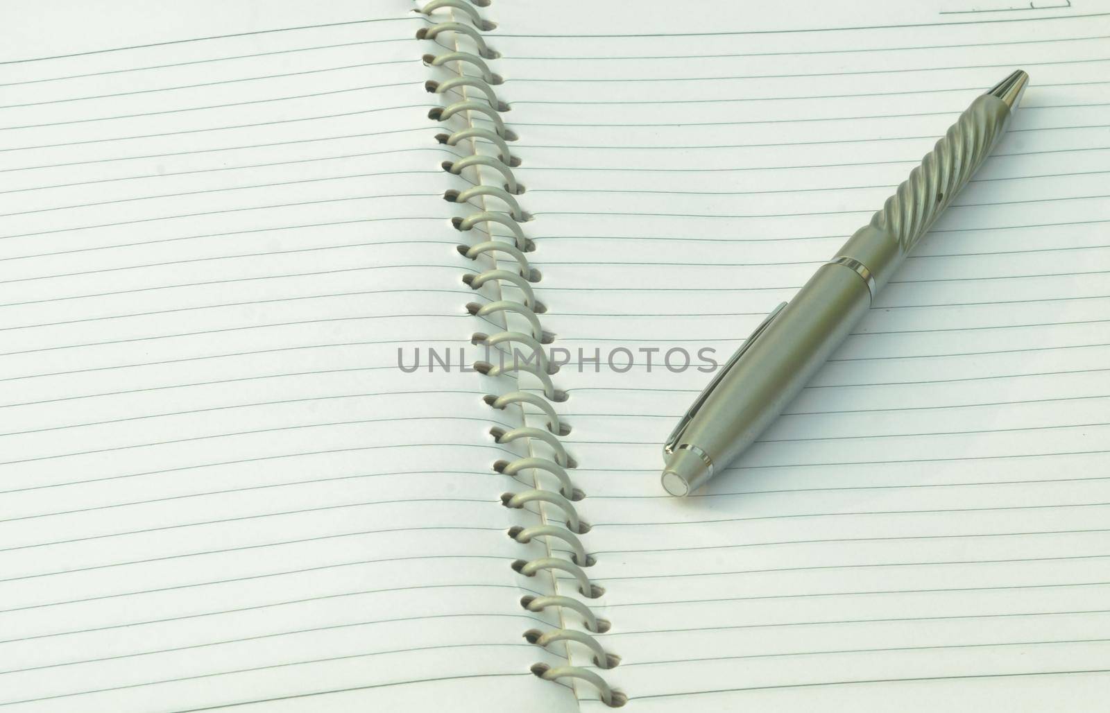 Close up of pen placed on spiral notebook. Full frame shot. High angle view. Business education background. by sudiptabhowmick