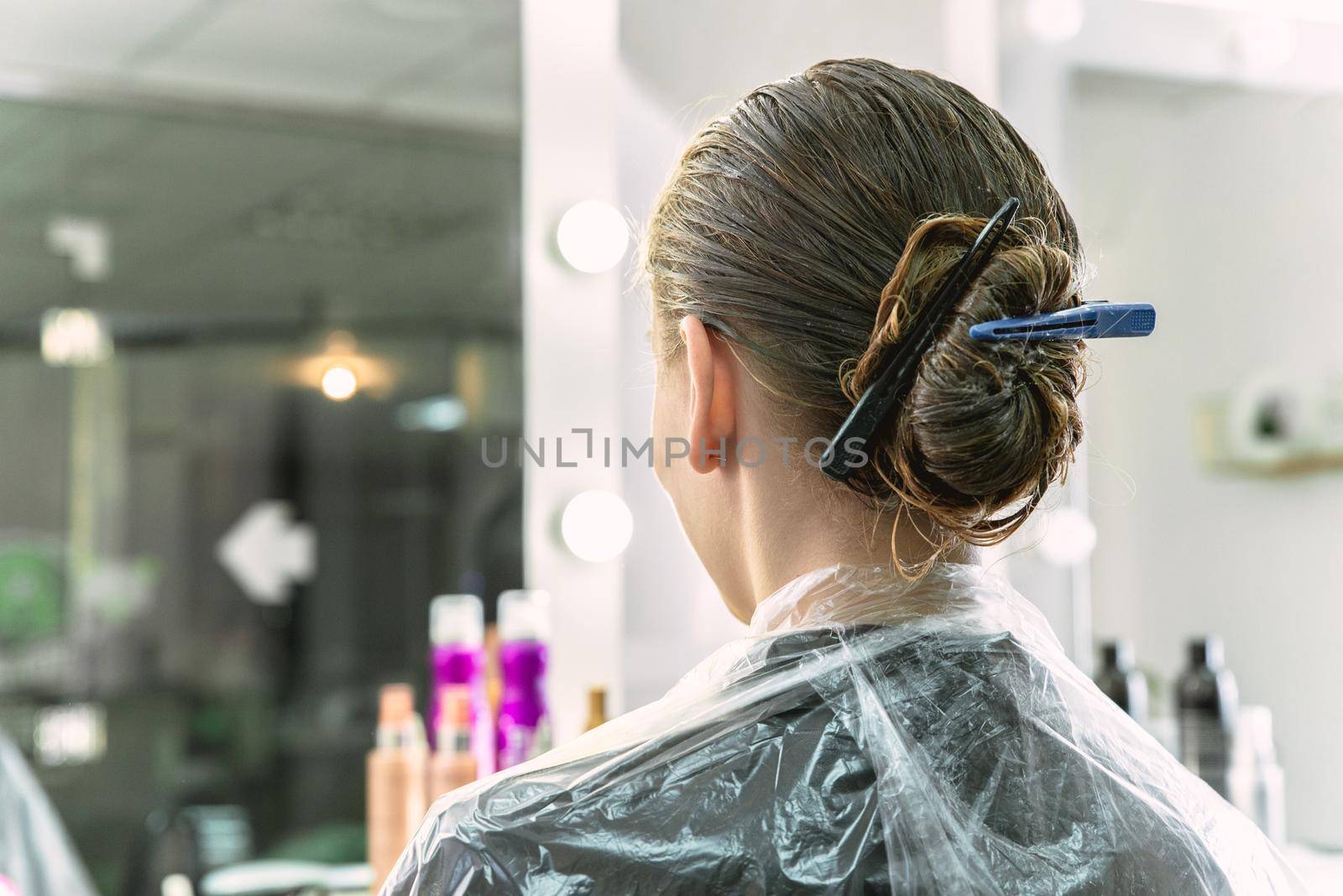 hair coloring in a beauty salon, young girl during dyeing process by Mariakray
